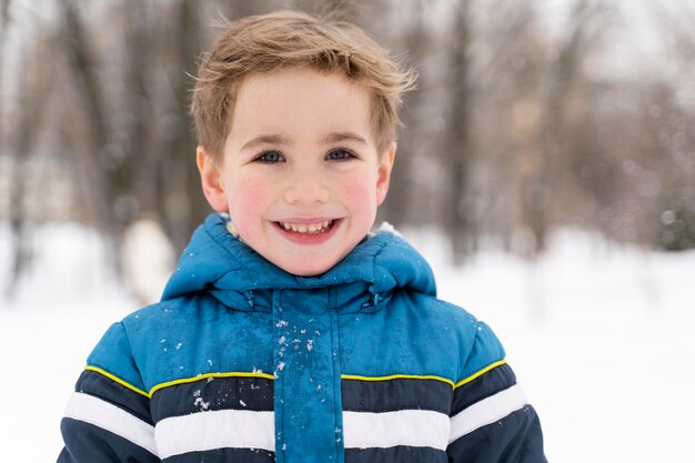 雪の中で遊んでいるn幸せな子供を閉じます