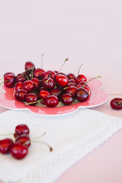 Крупный план салфетки и сочной красной вишни на тарелке