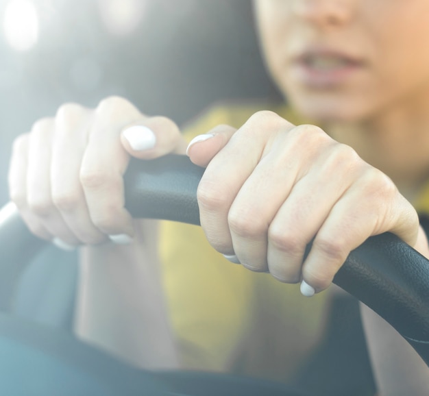 Close-up nervous woman holding the steering wheel