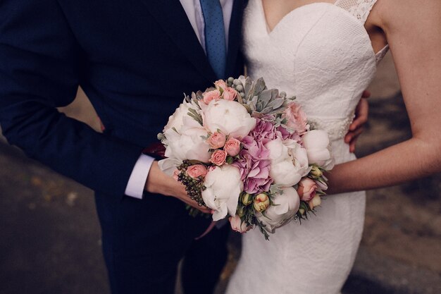 Close-up of newlyweds holding the wedding bouquet