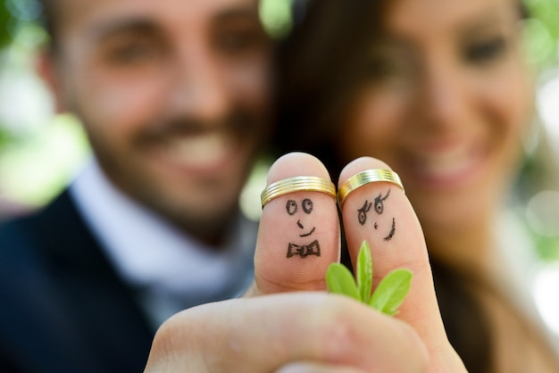 Close-up of newlyweds painted at fingers