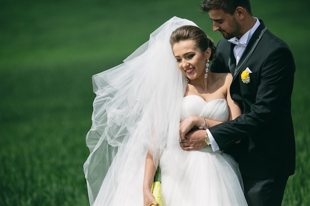 Close-up of newlyweds walking on the grass