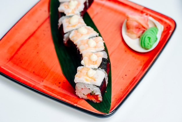 Close up of the nori sushi covered with shrimp, in white background