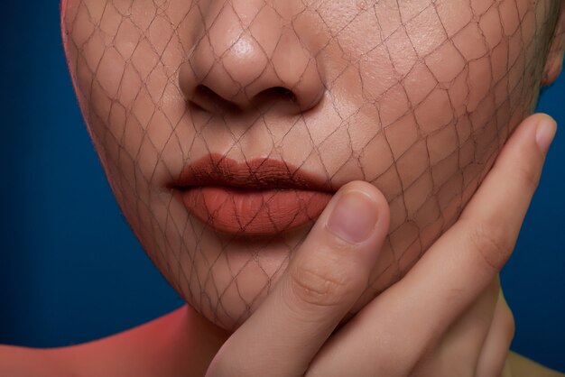 Крупный план носа и рта неузнаваемой женщины, позирующей в студии