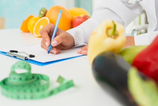 Close-up nutritionist writing prescription