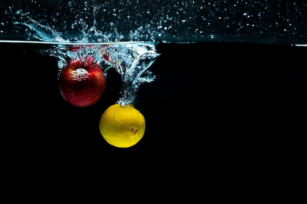 閉じる。オブジェクトの撮影。水にレモンとリンゴ。