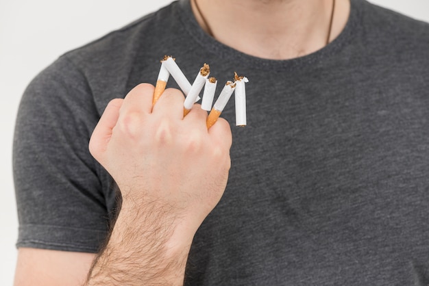 Бесплатное фото Крупный план мужской руки, показывая сломанную сигарету в руке