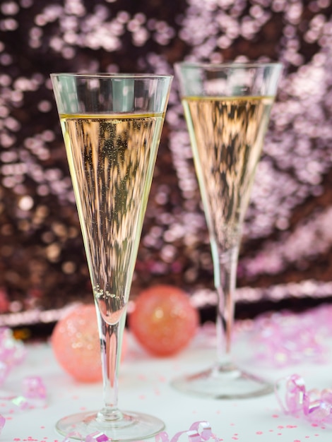 Бесплатное фото Крупный план бокалов для шампанского с розовыми шарами