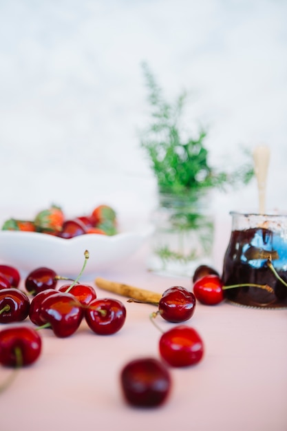 Бесплатное фото Крупный план сочные вишни с вареньем на столе