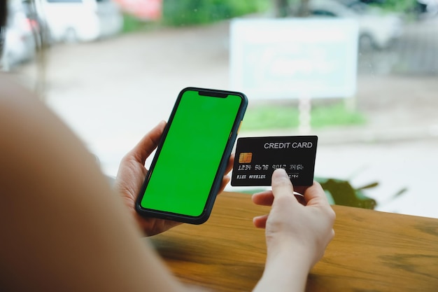커피숍에서 모바일 스마트폰과 신용카드로 마사지를 보내는 여성 클로즈업