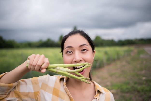 Foto gratuita da vicino il bel contadino raccoglie gli asparagi in mano e si avvicina alla telecamera.