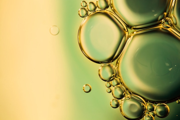 クローズアップの油性泡とカラフルな水の背景の液滴