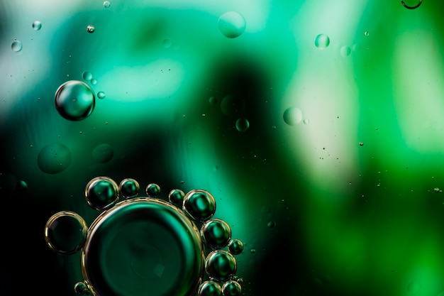 Close-up oily bubbles and droplets in colourful watery backdrop