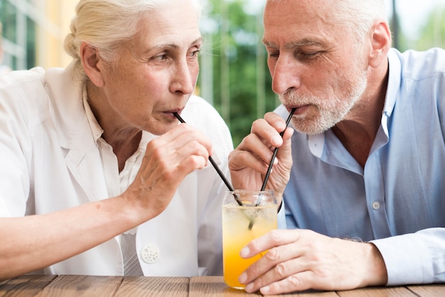 クローズアップの老夫婦がジュースを飲む