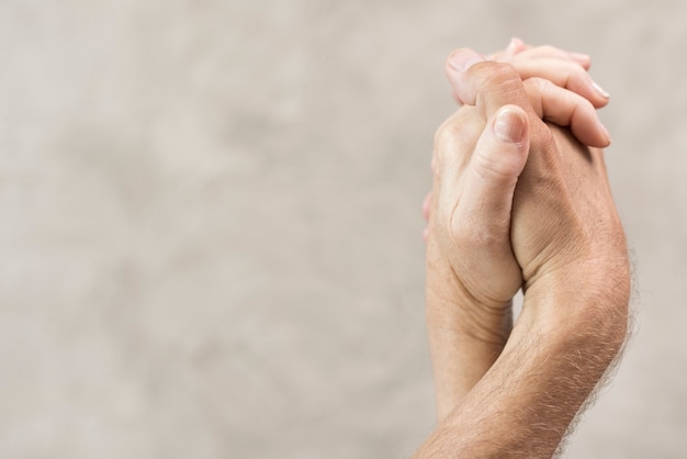 Close-up old couple holding hands with blurred background