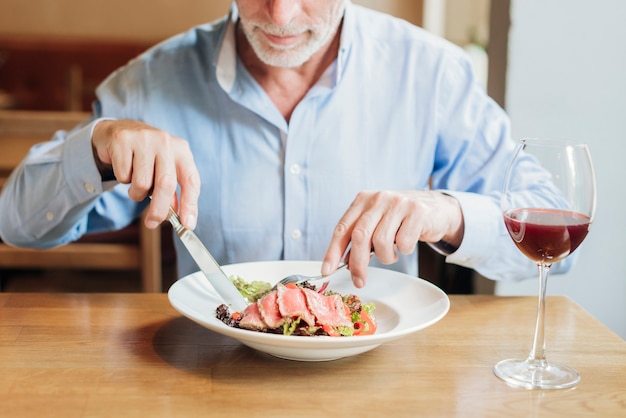 Foto gratuita mangiatore di uomini anziano del primo piano sano