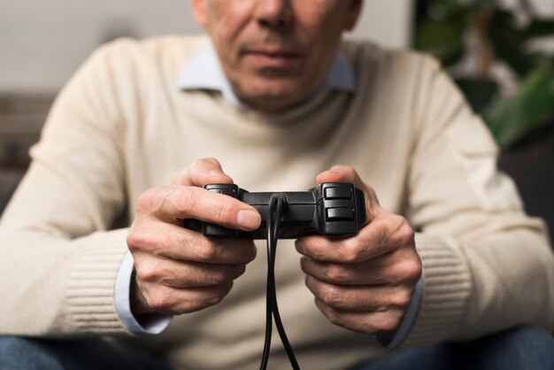 Close-up old man holding controller