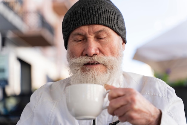 Free photo close up old man holding cup