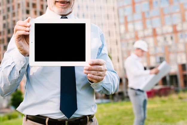 Free photo close-up old man holding up a tablet