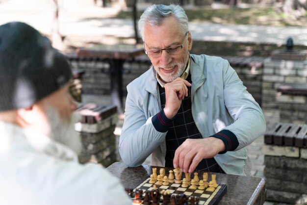 Primi piani vecchi che giocano a scacchi