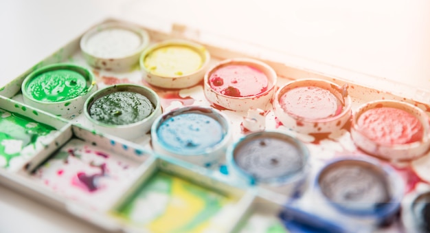 Close-up of a old messy watercolor palette