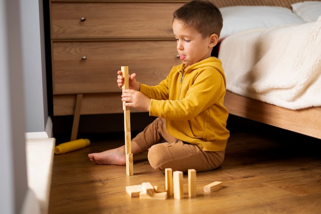 Бесплатное фото Закройте ребенка, играющего в своей комнате