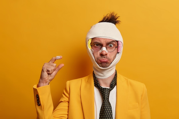 Бесплатное фото Крупным планом - раненый мужчина с темным синяком под глазами и сотрясением мозга, носит повязку