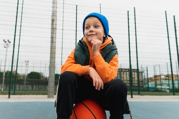 Бесплатное фото Крупным планом на маленького мальчика, играющего в баскетбол