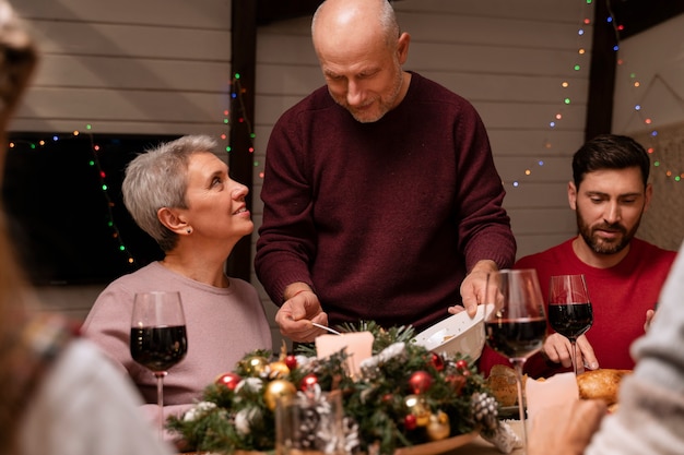 Бесплатное фото Крупным планом людей, наслаждающихся рождественским ужином