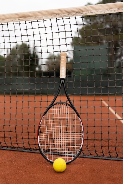 Бесплатное фото Крупным планом на теннисном мяче и ракетке во дворе