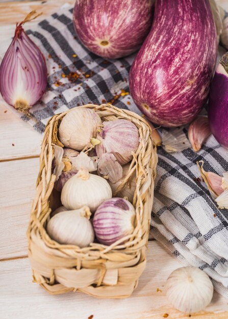 Close-up of onions near eggplants on cloth
