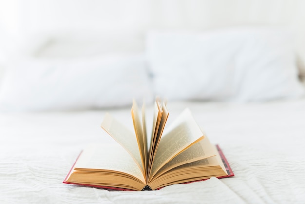 Close-up of open book on bed