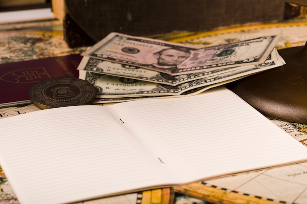 Close-up of open notepad with banknotes and passport