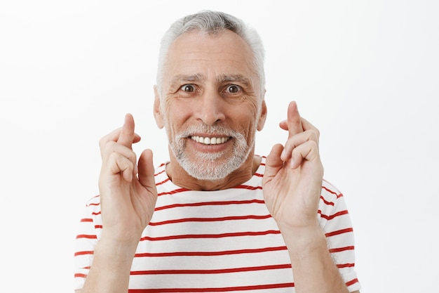 Free photo close-up of optimistic hopeful senior man, cross finger good luck, making wish