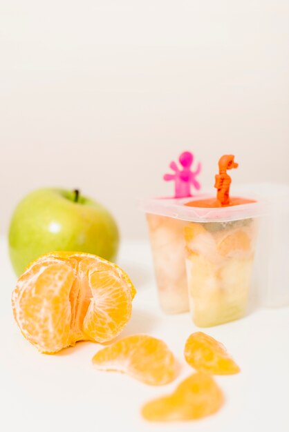 Close-up of orange; green apple and popsicle mold