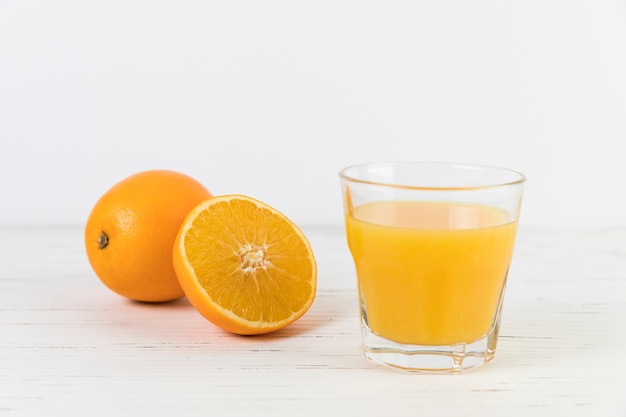 テーブルの上のオレンジジュースのガラスを閉じる