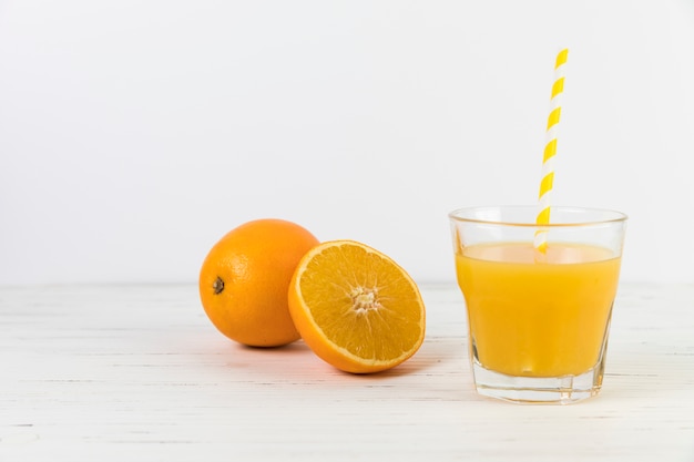 Close up orange juice glass with straw