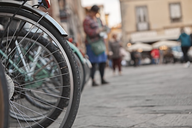 Закройте вверх по наружной съемке колес велосипедов, припаркованных на улице.
