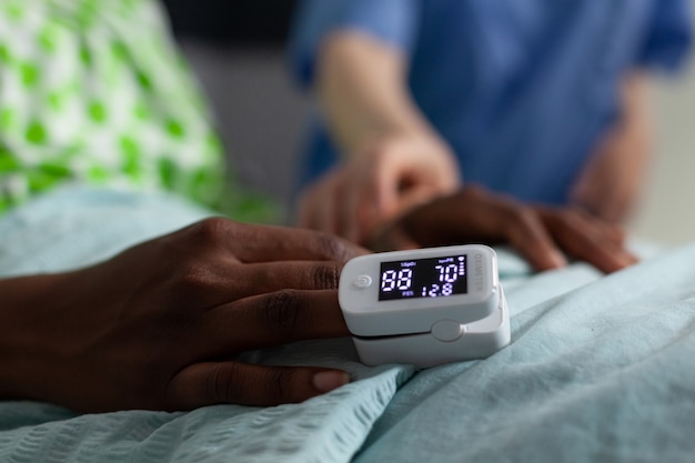 Close up of oximeter on african american girl hand