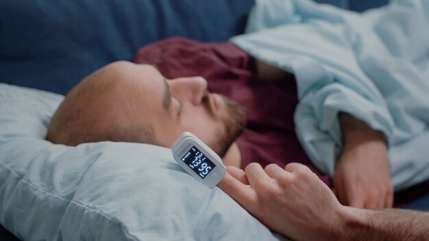 Free photo close up of oximeter on hand of ill person resting