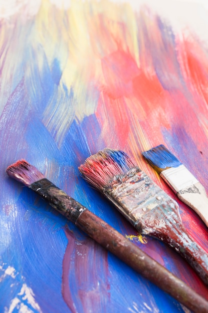 Close-up of paint brushes and abstract textured background