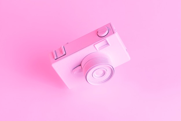 ピンクの背景に対して塗られた古いカメラのクローズアップ
