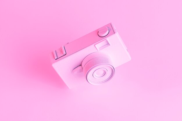 Close-up of painted old camera against pink backdrop