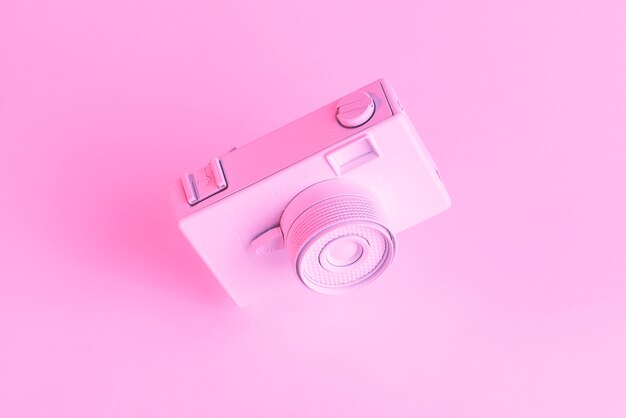 Крупный план окрашенной старой камеры на розовом фоне