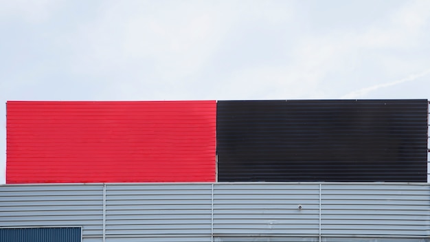 Free photo close-up of painted red and black big blank hoarding against sky