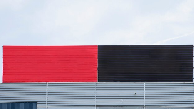 Close-up of painted red and black big blank hoarding against sky