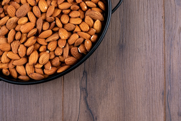 Close-up a pan of almond on wooden table. horizontal