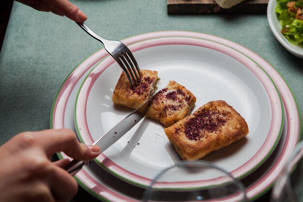 Close-up pancakes with meat homemade in white plate on a served table with another meal, knife, fork horizontal