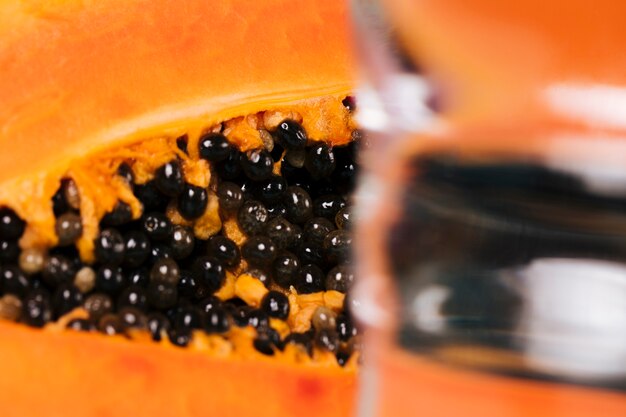 Free photo close-up of papaya fruit and glass of water