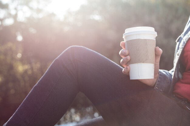 Close-up of paper cup in the hand of a girl